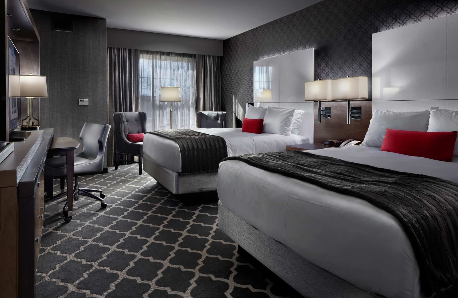 a grey and red room with two queen beds