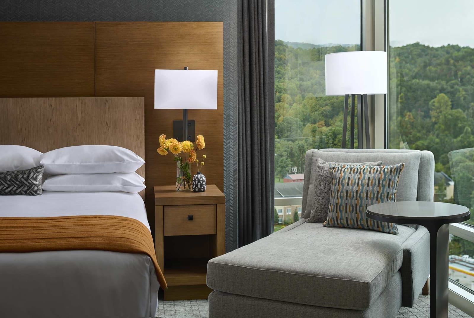 A close up shot of a corner window and lounge chair in a guest room at the cherokee hotel and  casino